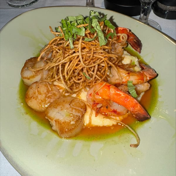 Seared scallops and shrimp with crispy fried onions, fresh basil, and a green sauce.